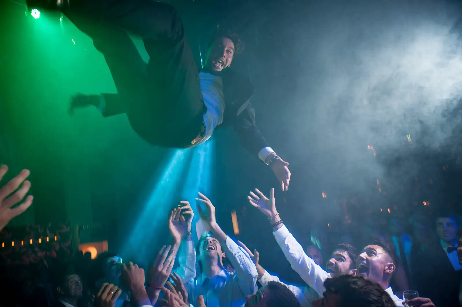 Invitados tirando al novio por el aire en la fiesta